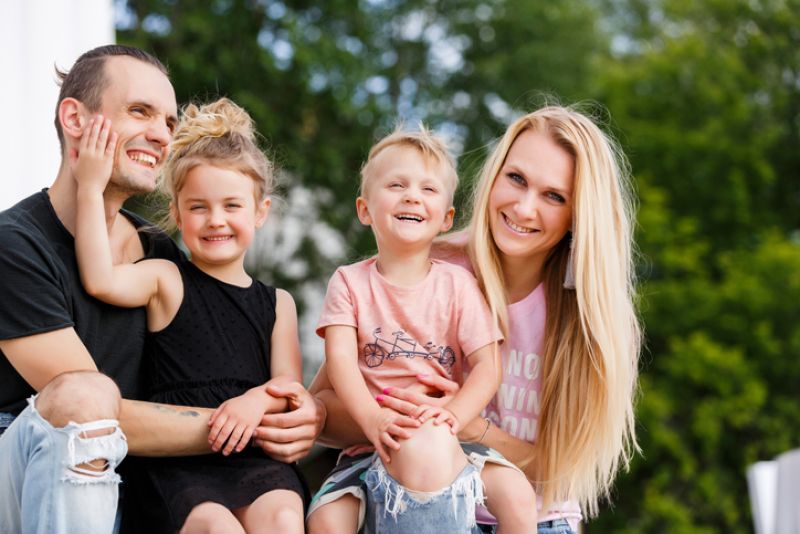 Family of four outside posing for family photos.